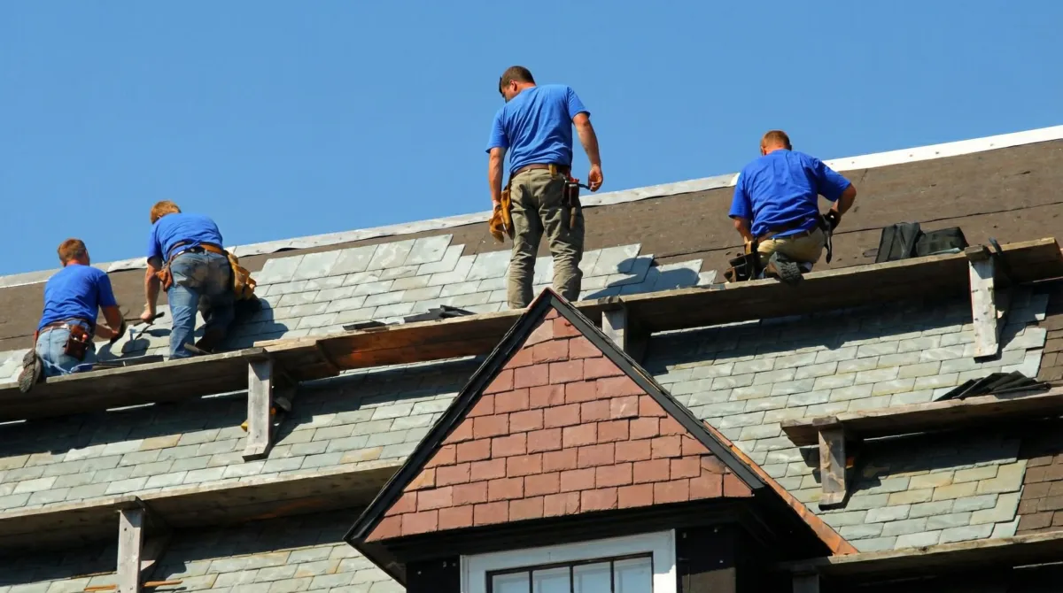 Roof replacement in progress with a team of professional contractors installing new shingles on a residential home in Charleston, SC